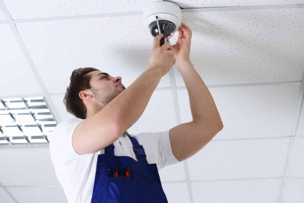 A technician is installing a CCTV security camera for a Gold Coast property